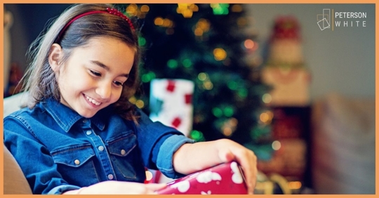 Young girl opening a Christmas gift
